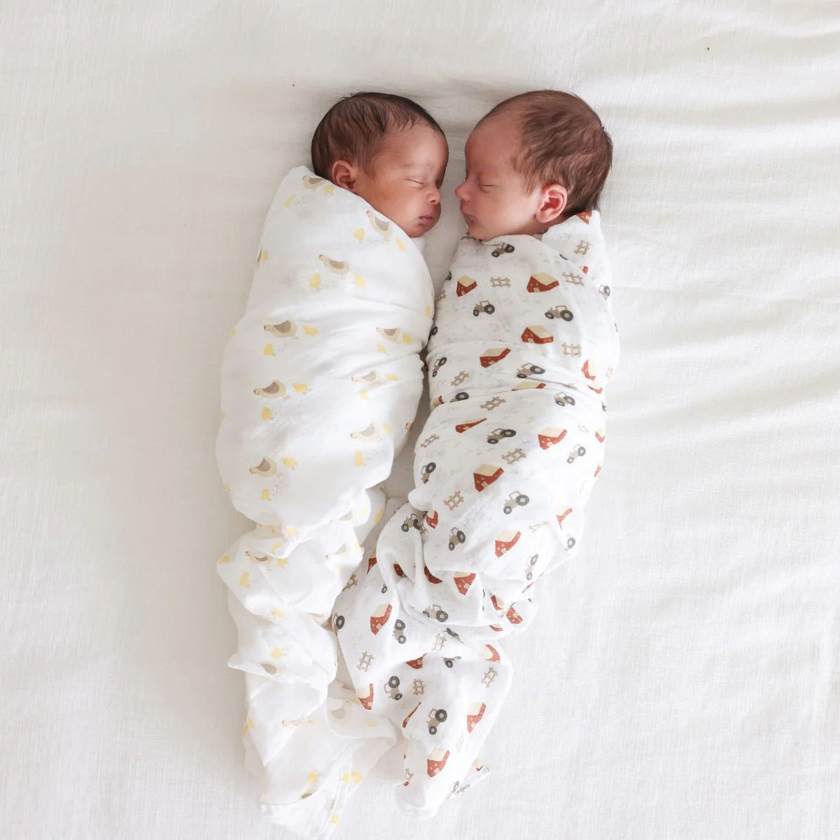 Swaddles worn by 2 sleeping babies.
