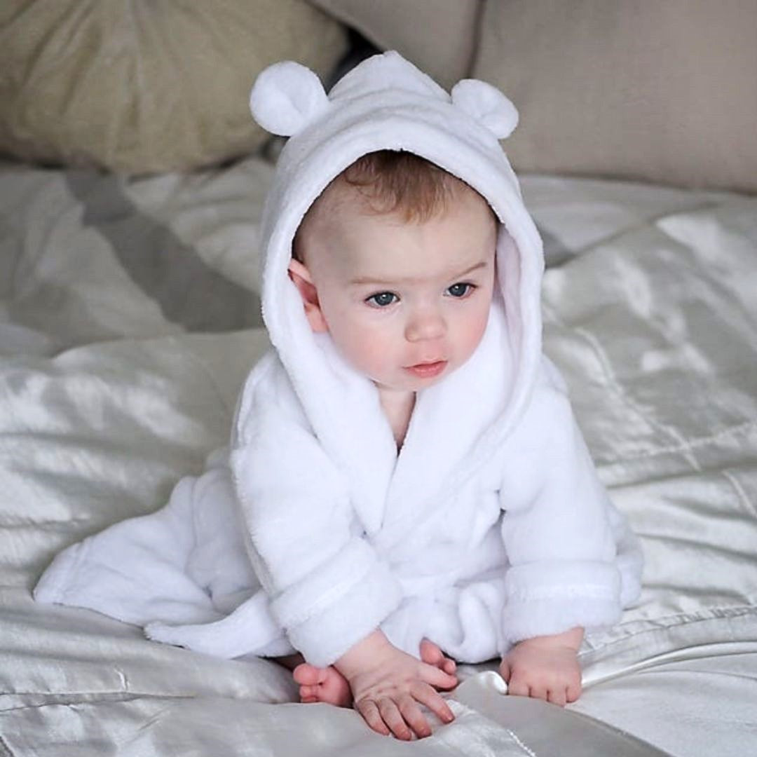Baby dressing gown in white worn by crawling baby.