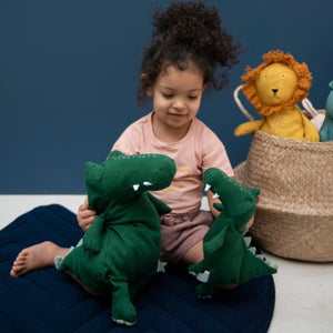 Lifestyle picture of child playing with the soft organic green mr crocodile soft toy from Trixie. Suitable from birth.
