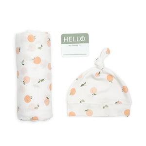 Hello world eco bamboo hat and swaddle gift set with soft peach design on white.