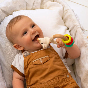 Sophie La Girafe Teether Rattle Toy with sensory rings. Show in lifestyle photo with smiling baby.
