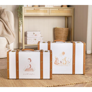 Two illustrated animal suitcase storage boxes with brown straps displayed on a nursery rug.