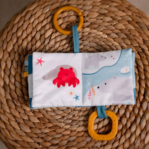 Soft ocean themed baby activity book with sensory pages, open on crab page