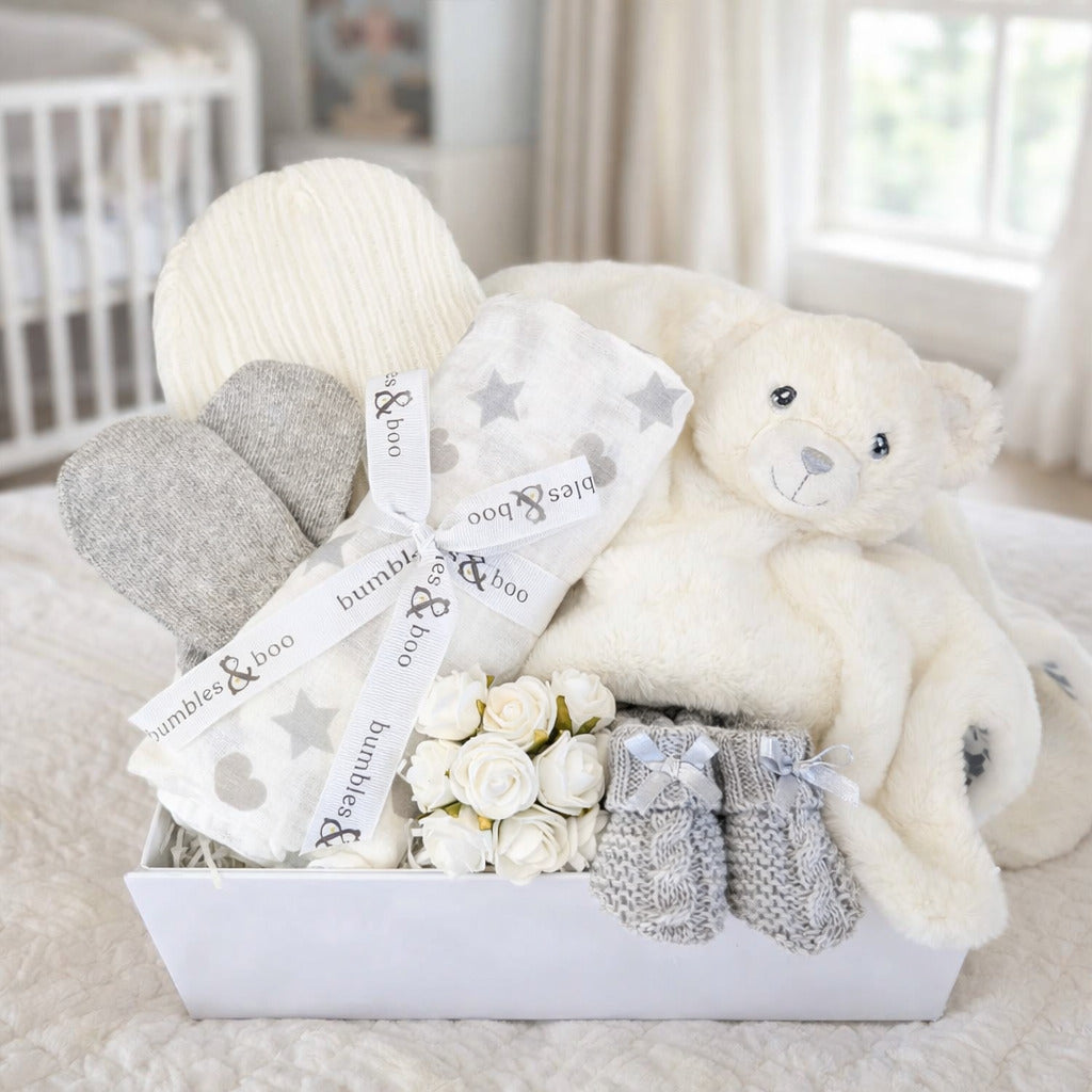 Baby box with white and grey presents to welcome a new baby.