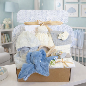 Gifts hamper for a baby boy with a knit hat and blanket set presents and blue elephant comforter soft toy.