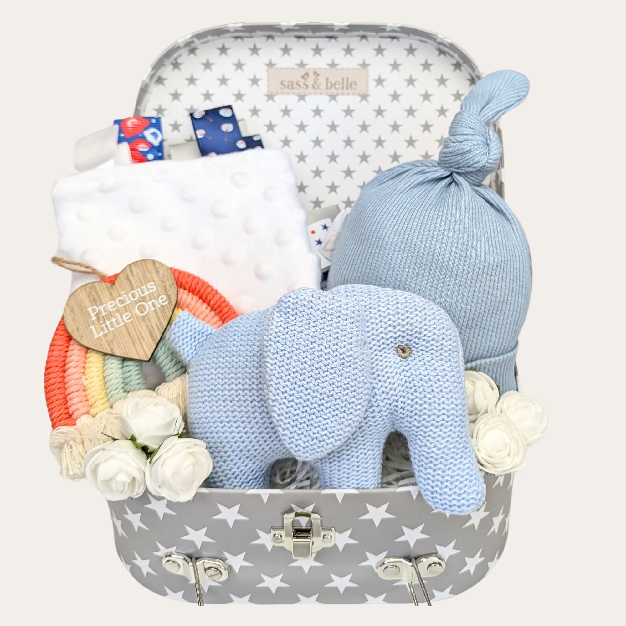 Baby boy gifts hamper with presents including blue elephant rattle and newborn hat. By Bumbles and Boo.