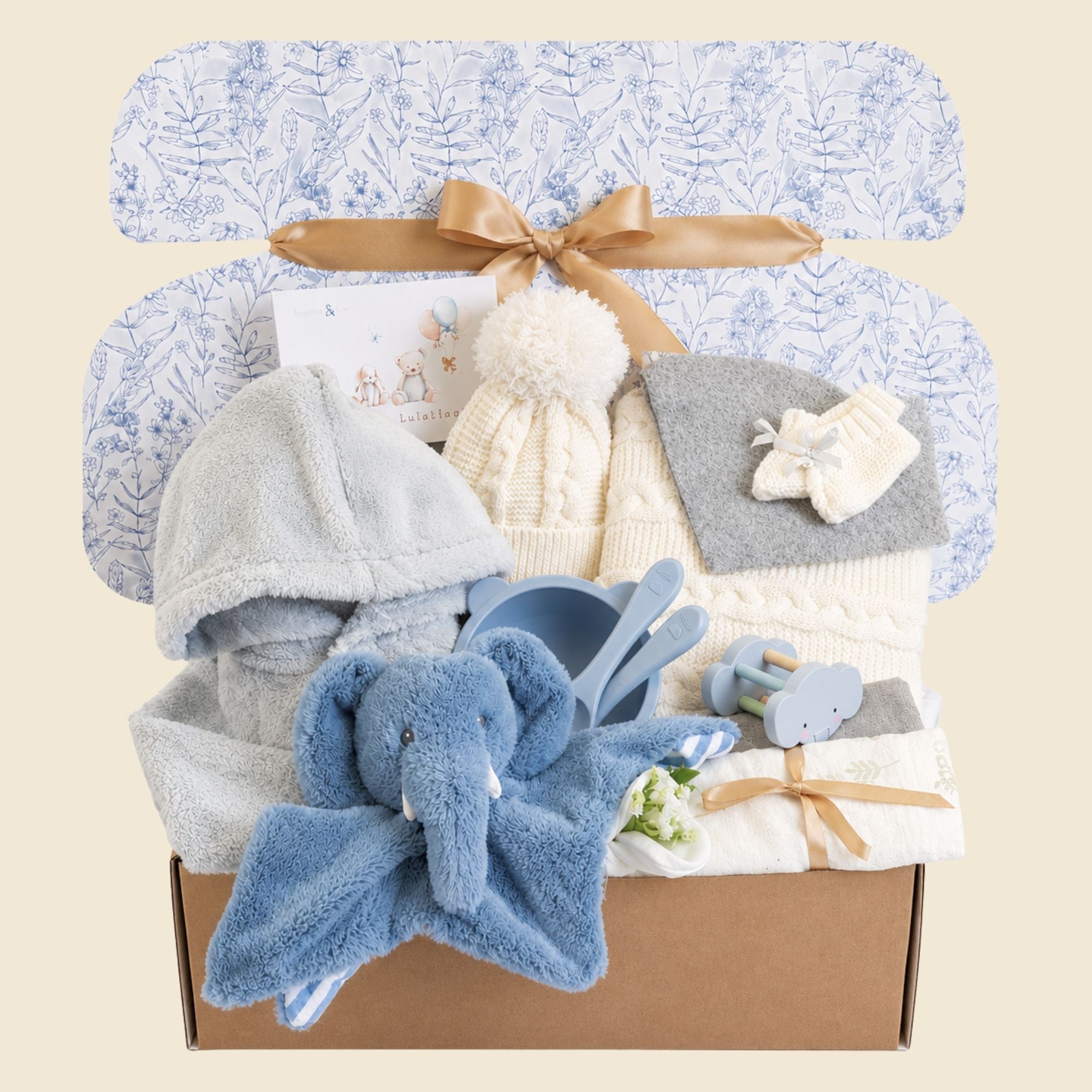 Gifts hamper for a baby boy with a knit hat and blanket set presents and blue elephant comforter soft toy.