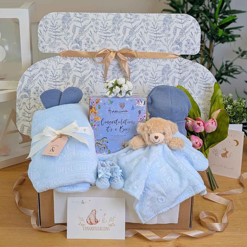 Baby boy hamper box with blue gifts including teddy bear comforter, blanket and chocolates for the new parents