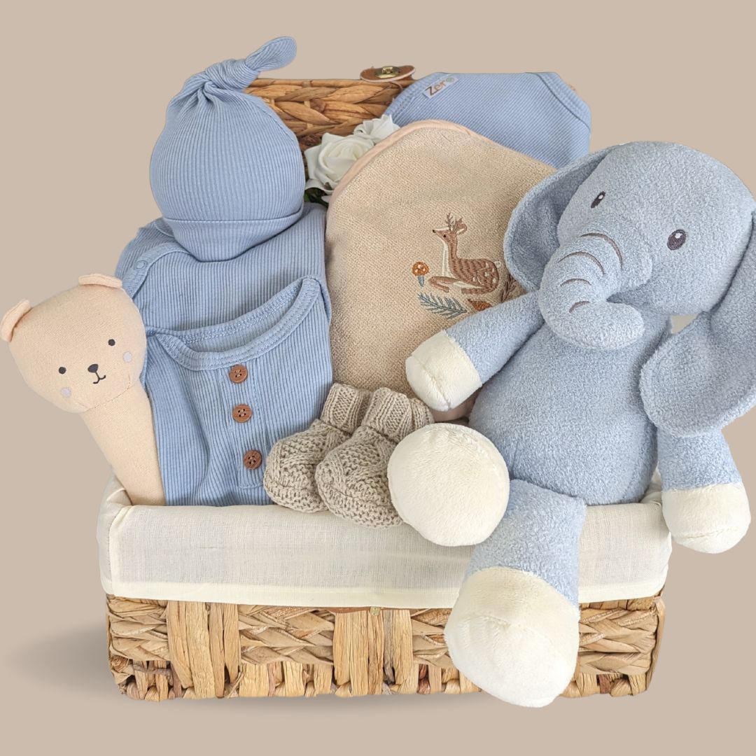 Baby boy hamper basket. Gifts include  Blue baby clothes gift set and elephant soft toy in an eco-hamper basket made from water hyacinth grass.