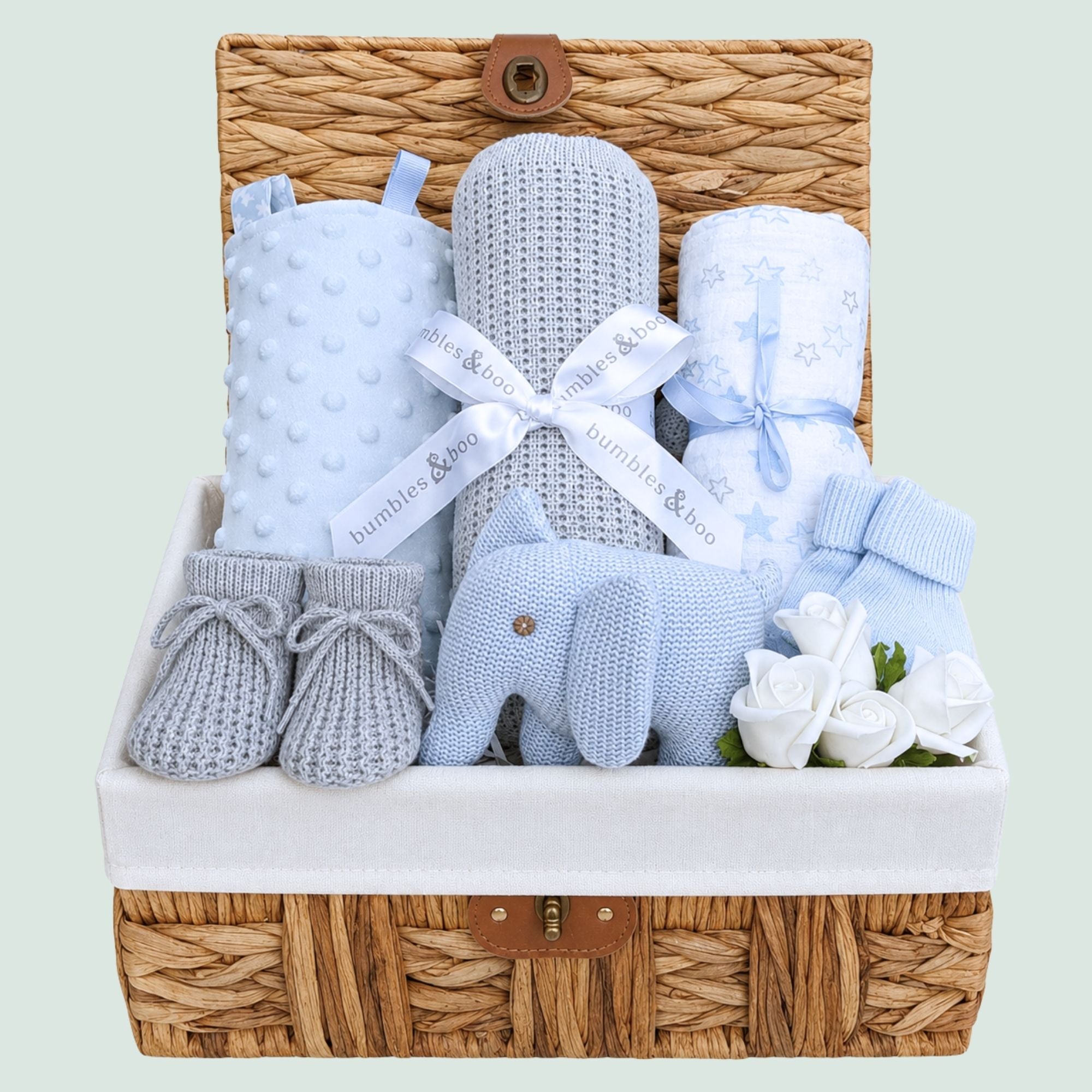 Gifts for a new baby boy in a hamper basket with grey and blue presents includes elephant rattle. Bumbles and Boo.