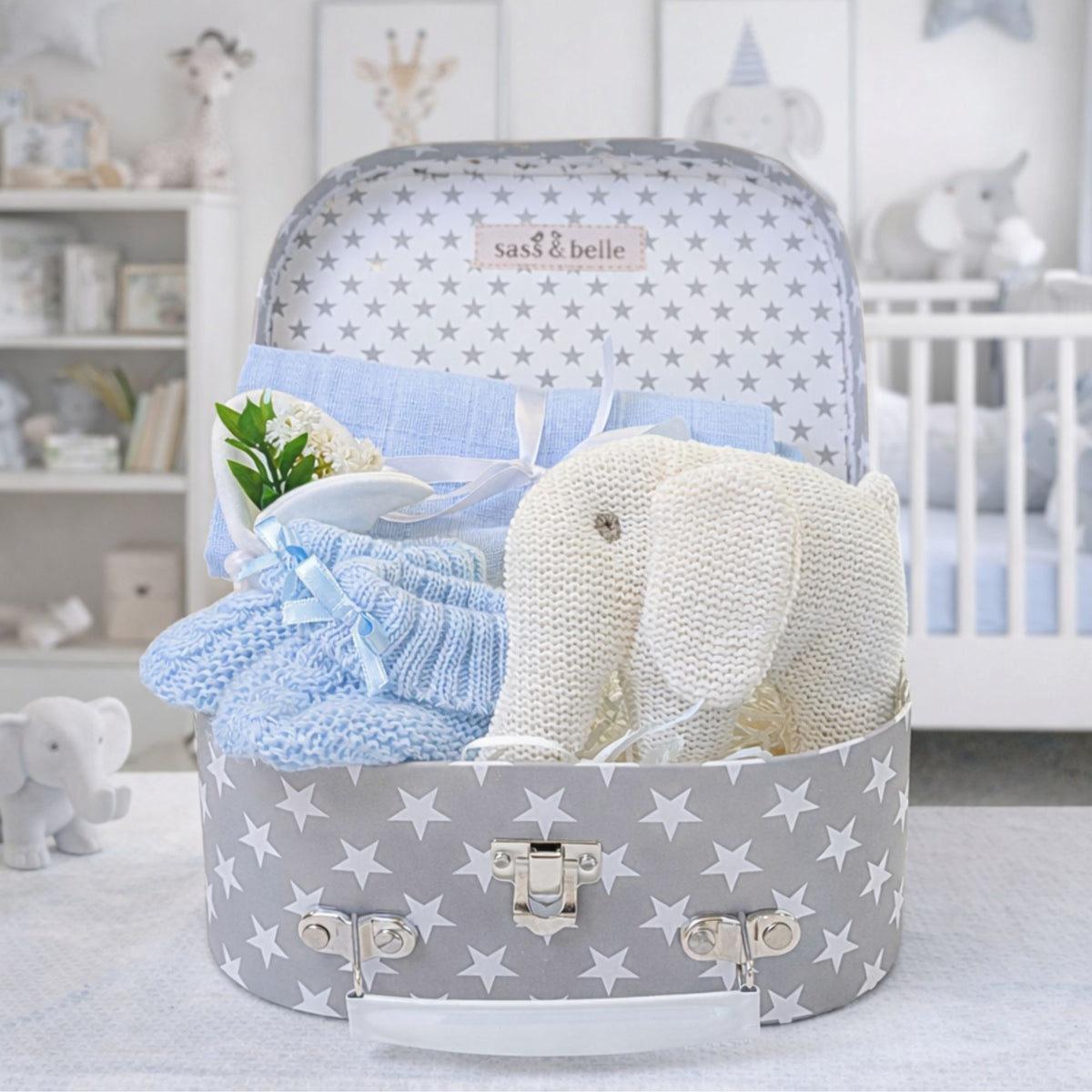 Baby boys hamper with a white elephant rattle and blue gifts for a newborn boy.