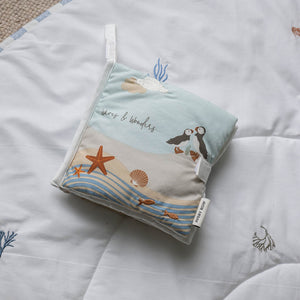 Folded Coastline baby fabric book showing its seaside cover and attachment loop.