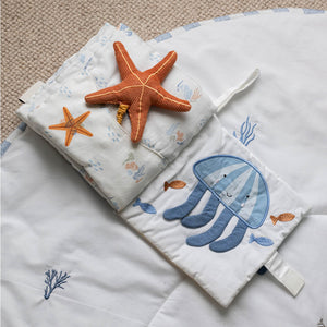 Open fabric book showing a raised orange starfish and blue jellyfish page.