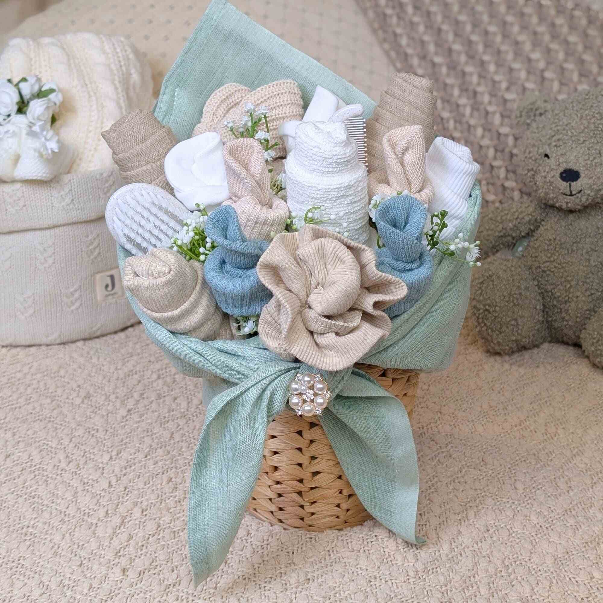 New baby gifts - sage green and beige baby clothing flower bouquet presented in a rattan plant pot by Bumbles and boo.