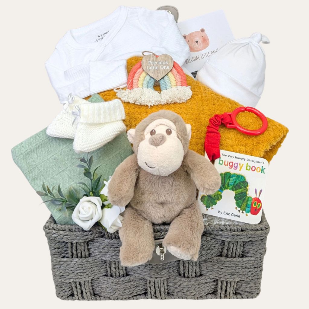 New baby gifts hamper basket by Bumbles and Boo. Presents include recycled monkey toy and white and sage green newborn essentials.
