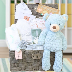 Baby gifts basket with blue bear and baby towel and grooming