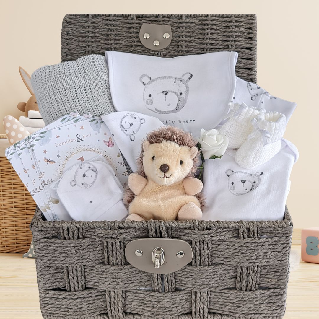 baby gifts basket with baby clothing, hedgehog soft toy, baby milestone cards and cellular baby blanket