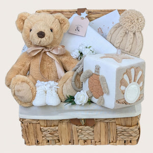 New baby gifts basket filled with presents including teddy bear and activity cube. Packed in a hamper by Bumbles and Boo.