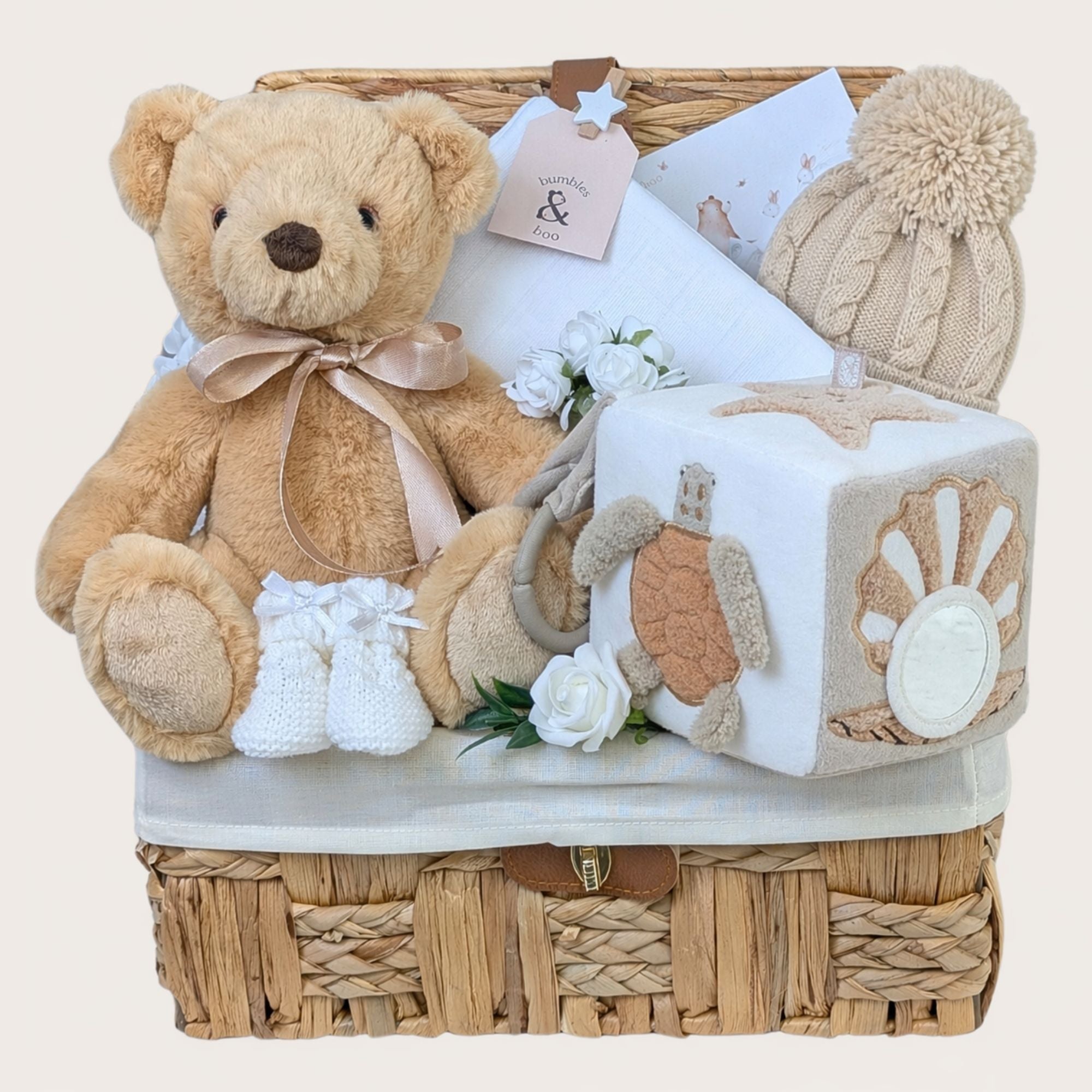 New baby gifts basket filled with presents including teddy bear and activity cube. Packed in a hamper by Bumbles and Boo.