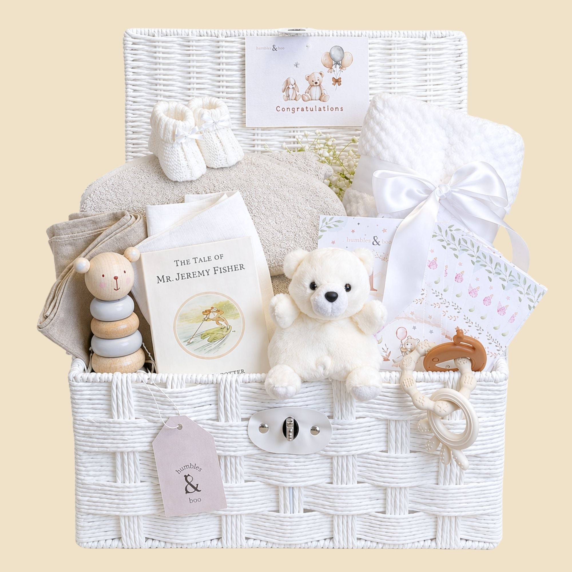 White baby hamper basket with presents for baby to include soft yo, blanket and wooden bear.