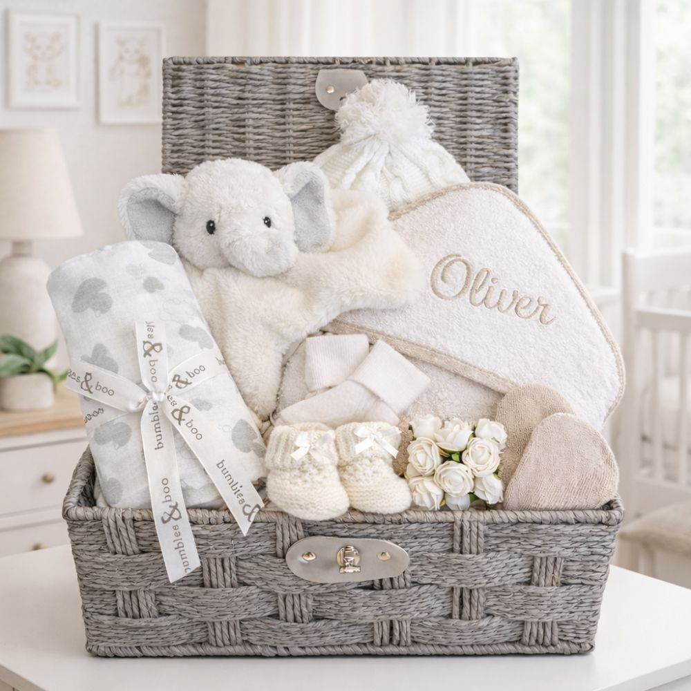 New baby gifts hamper with white and beige presents and elephant comforter