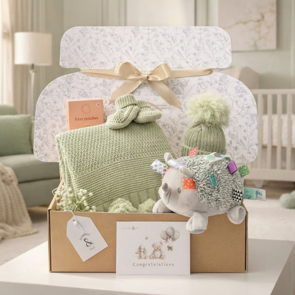 Neutral baby gifts in a baby hamper with apply green matching hat, booties and blanket
