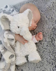 baby cuddling white elephant toy