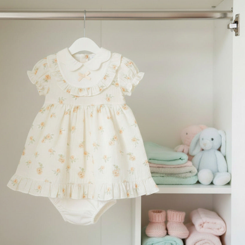 Baby girl clothing outfit of a dress and under pants. In Beige with a floral pattern