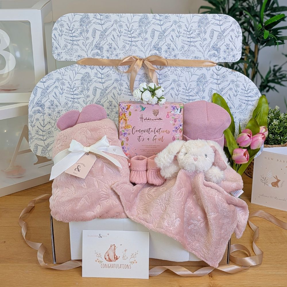 Baby girl box with gifts including pink blanket and matching comforter