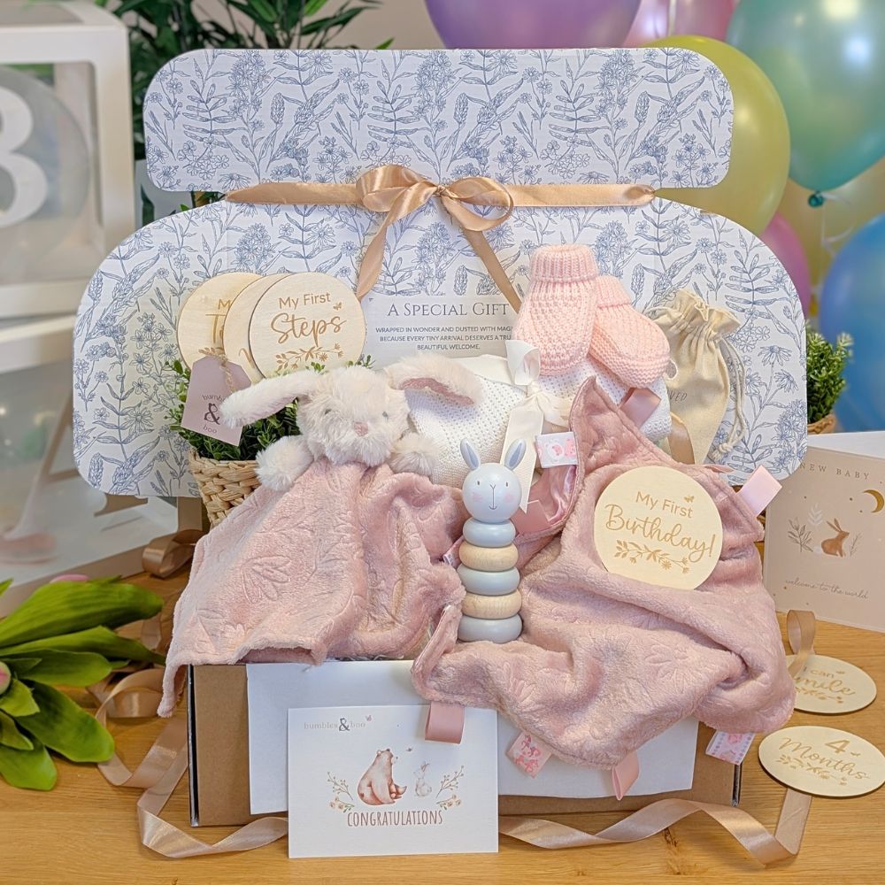 Baby girl gifts hamper with blush pink bunny and comforter set in a gifts box.