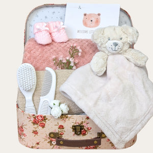 New baby girl gifts hamper in a floral suitcase. Presents include white bear comforter and pink blanket. Bumbles and Boo.