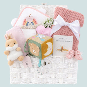 Baby girl gifts hamper with congratulations presents with a bear and bunny theme in a white gift basket.