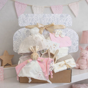 New baby girl hamper presented in an eco-friendly gift box. With pink and cream gifts including flopsy bunny, blanket and dressing gown.