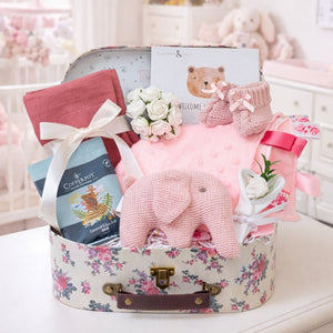 Baby girl hamper for a newborn baby with gifts including a pink elephant rattle and treats for mum.