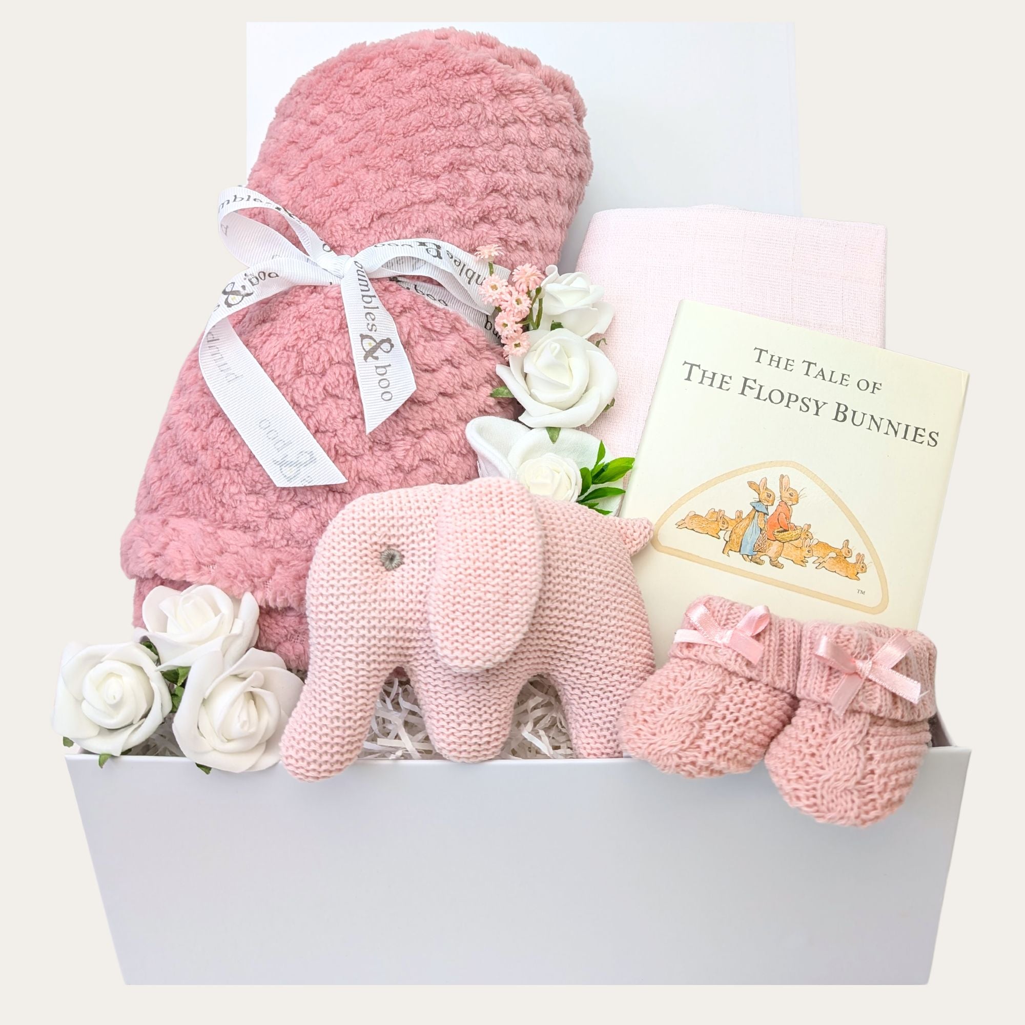 Baby girl gifts in a box with dusky pink blanket and pink elephant rattle. Hamper designed by Bumbles and Boo.