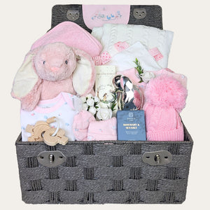 Newborn baby girl gifts hamper, with pink gifts packed in a hamper basket designed by Bumbles and Boo.