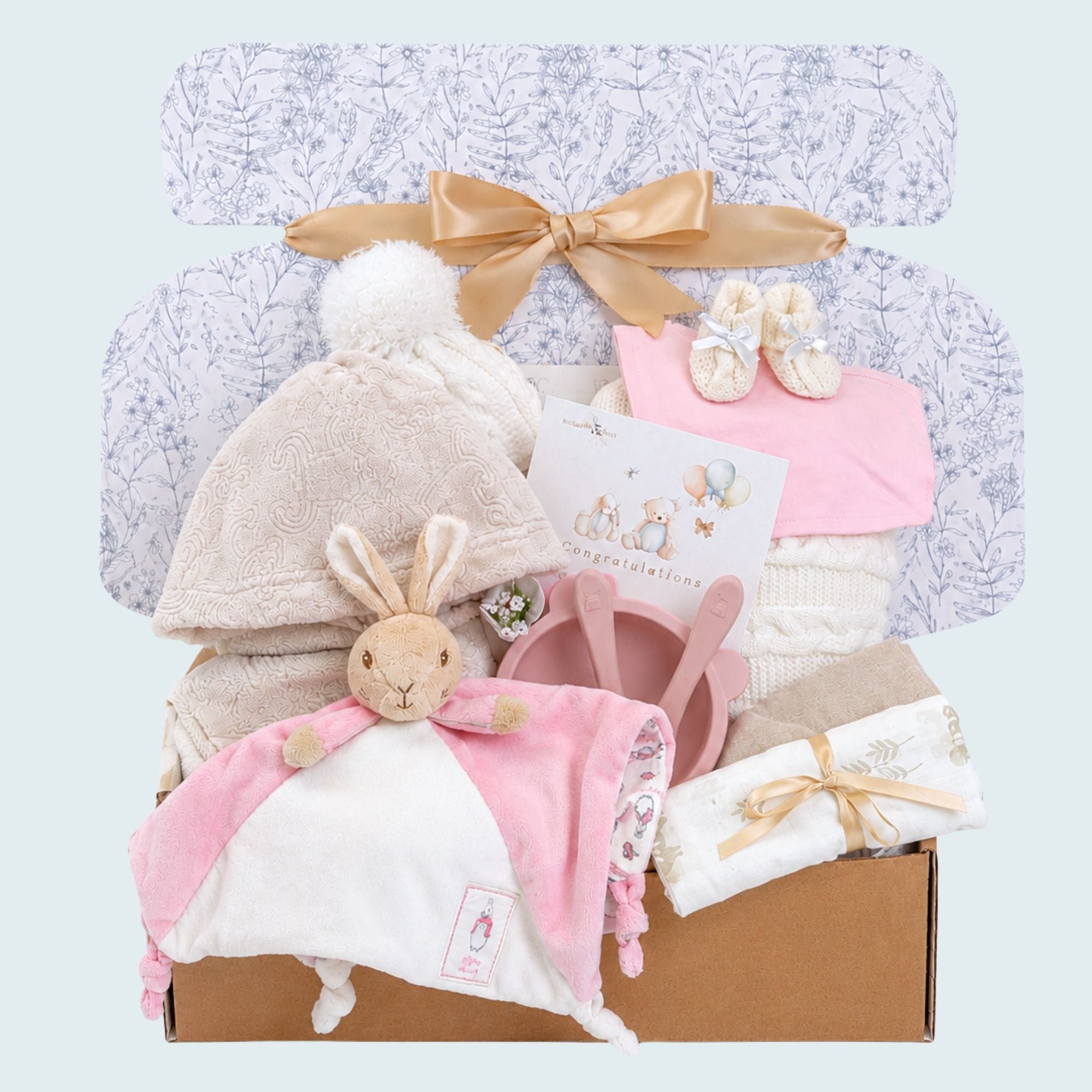 New baby girl hamper presented in an eco-friendly gift box. With pink and cream gifts including flopsy bunny, blanket and dressing gown.
