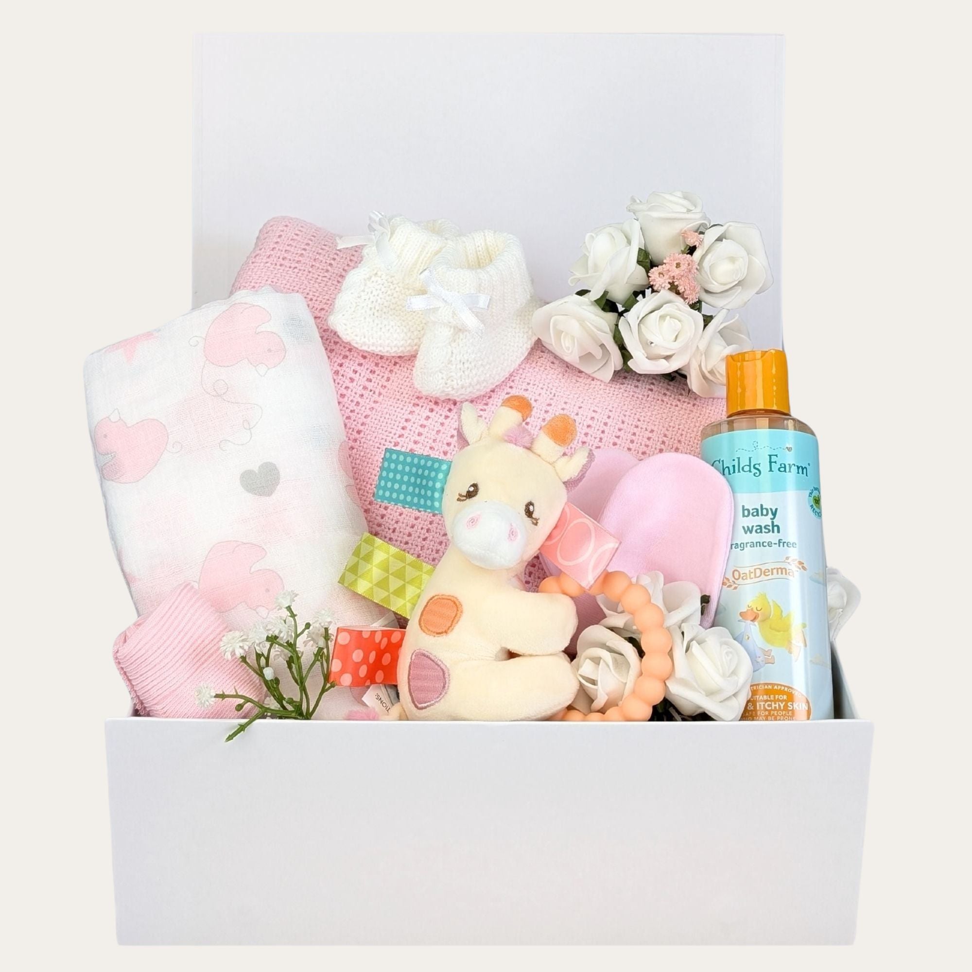 Newborn baby girl hamper. This white gifts box contains presents including a pink cellular blanket, muslin square and tilly giraffe teether. Bumbles and Boo.