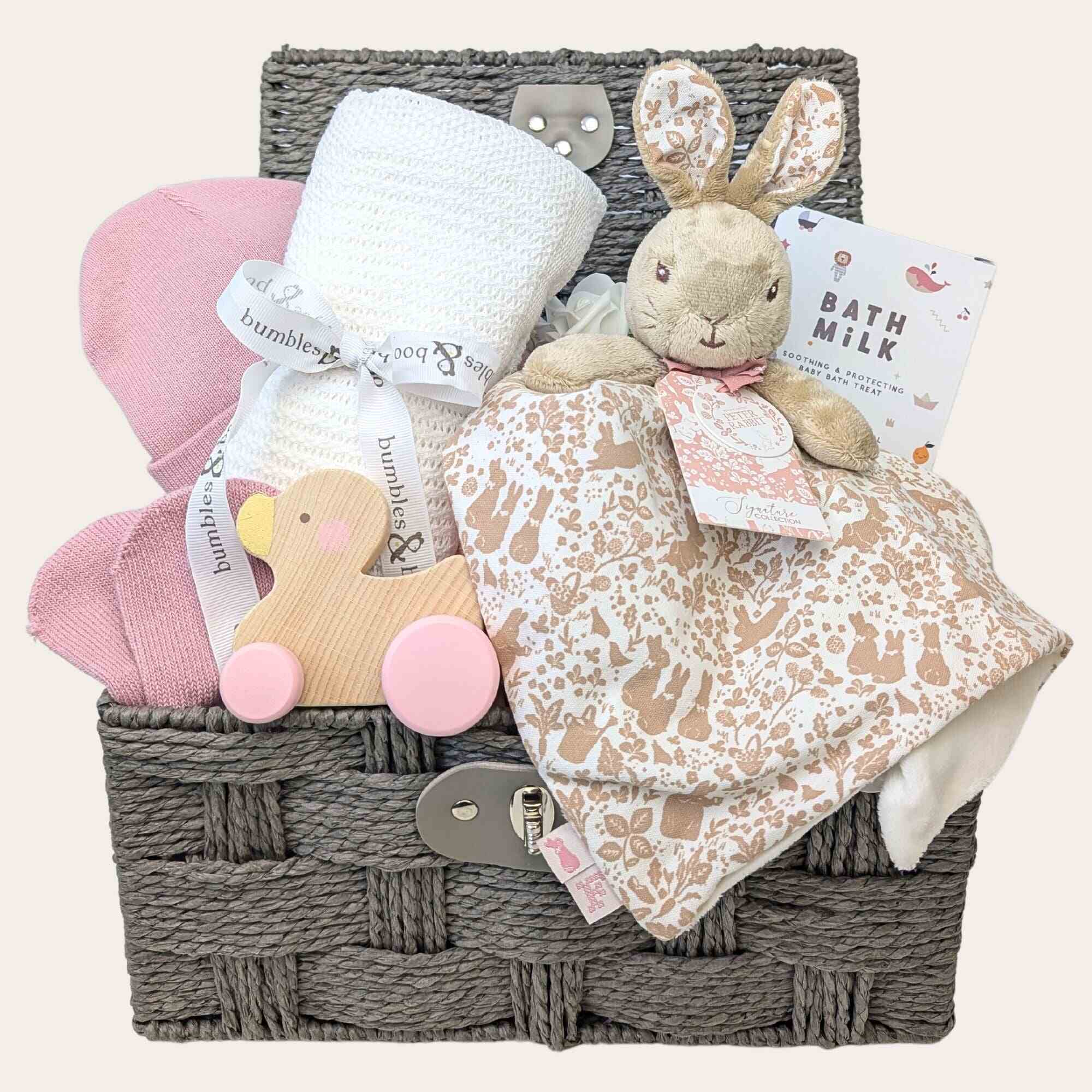 Baby girl gifts in a hamper basket with rabbit baby comforter and white blanket. Bumbles and Boo.