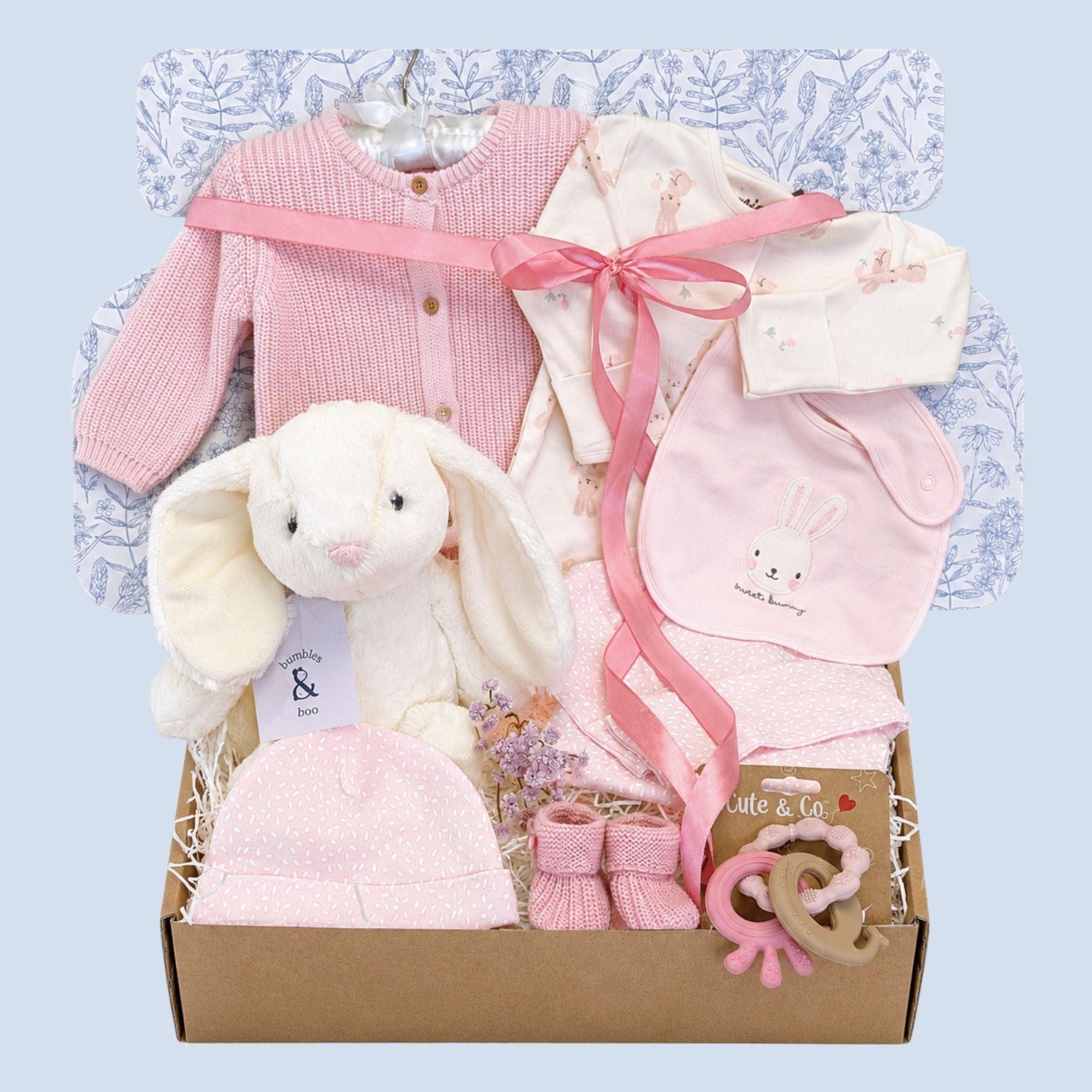 Baby girl gifts set in illustrated postal box, hamper contains pink bunny-themed clothing and white rabbit soft toy