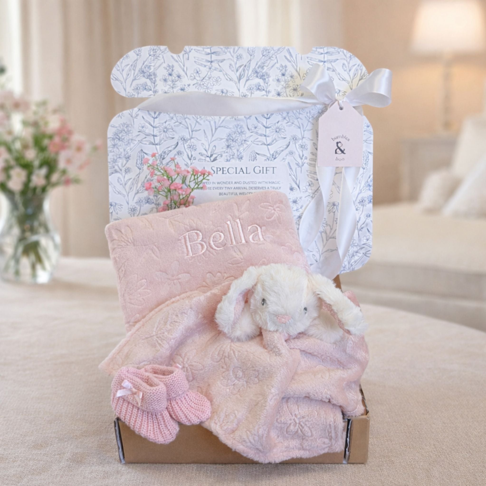 Baby girl hamper in a box with gifts including matching bunny comforter and blanket set.