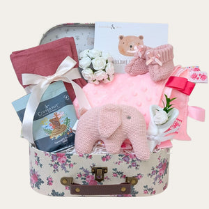 Baby girl hamper with gifts including pink organic elephant toy, comforter and present for parents.
