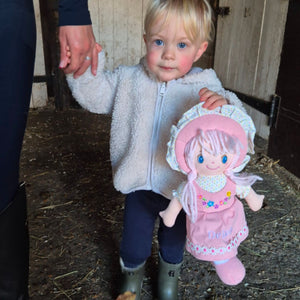 A pink doll which has a dress and can be personalised.