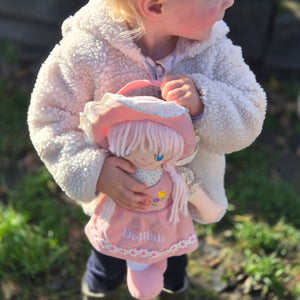 A sweet baby doll which has a pink dress and can be personalised.