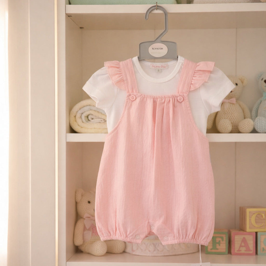 Baby girls dungaree set with pink romper and white top, displayed in nursery setting. Soft baby girl clothes outfit with button straps.