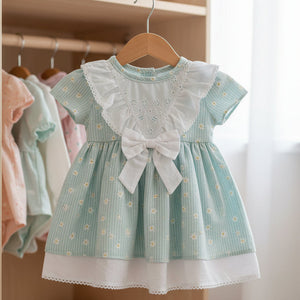 Baby girls woven dress with bow and white pants set in soft blue. 100% cotton baby clothes outfit displayed flat on white background.