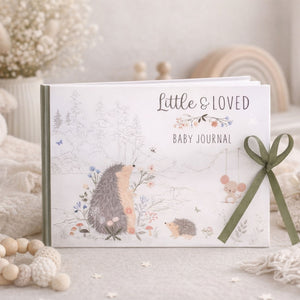Baby journal with hedgehog illustrations and a green ribbon