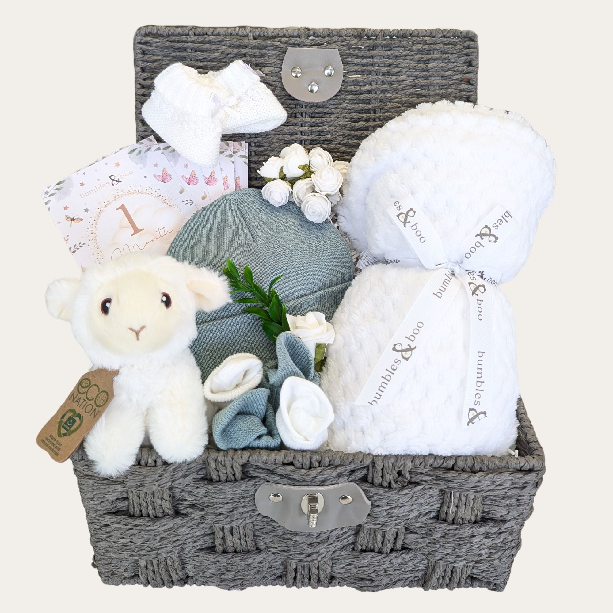 Baby shower gifts hamper with white blanket and lamb soft toy packed in a basket by Bumbles & Boo.