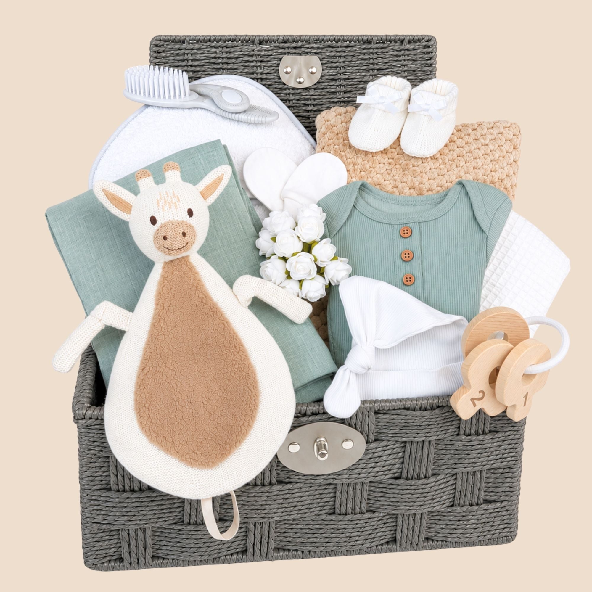 Baby shower hamper gifts with giraffe baby comforter and green baby clothes packed in a basket by Bumbles & Boo.
