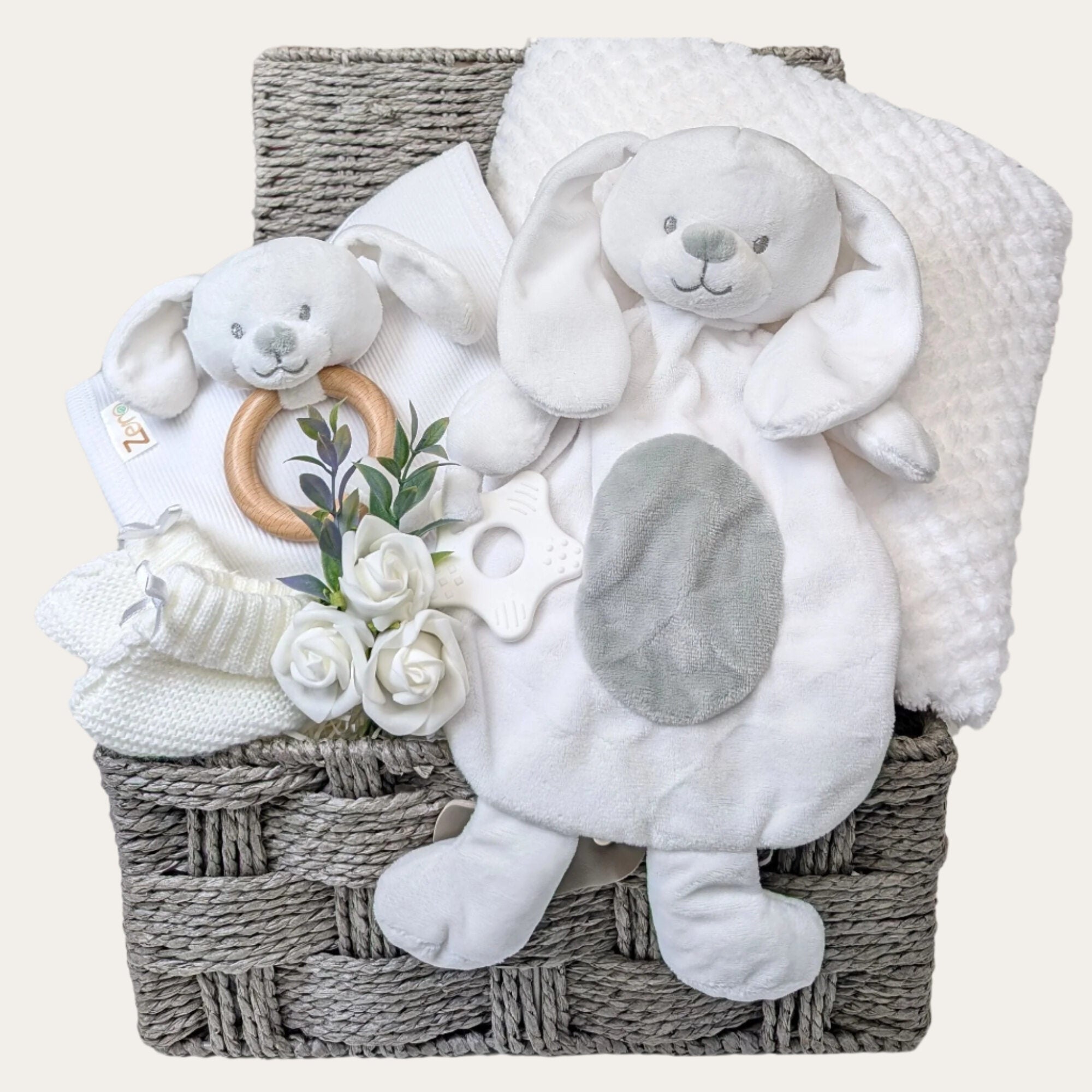 Baby shower hamper gifts by Bumbles and Boo displayed in a basket with white bunny comforter and teether.
